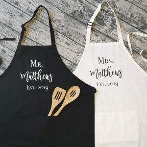 “Matching his and hers apron set crafted from cotton fabric”